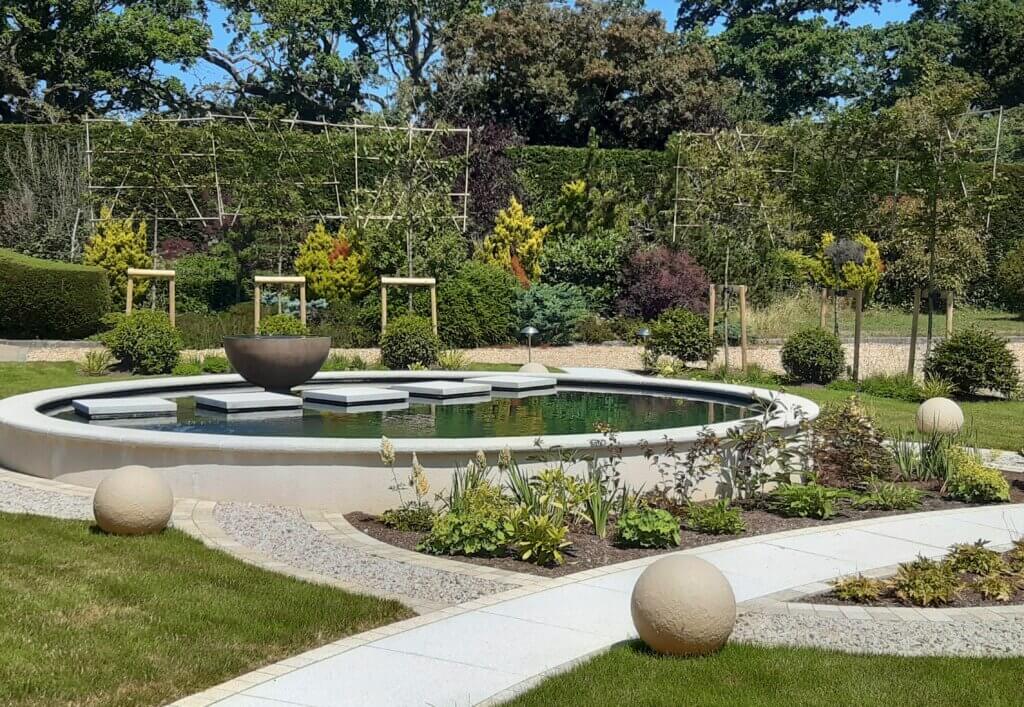 A contemporary garden featuring a Koi pool designed by Anna Helps - Sussex based garden designer. 